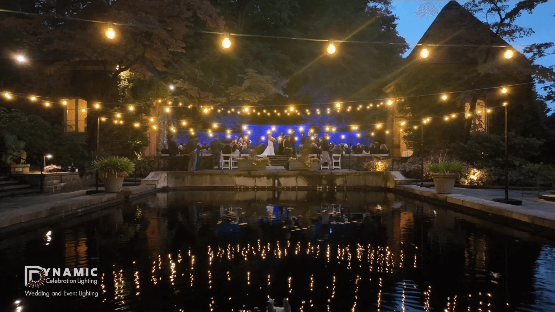 String and bistro lights strung overhead at an outdoor wedding reception