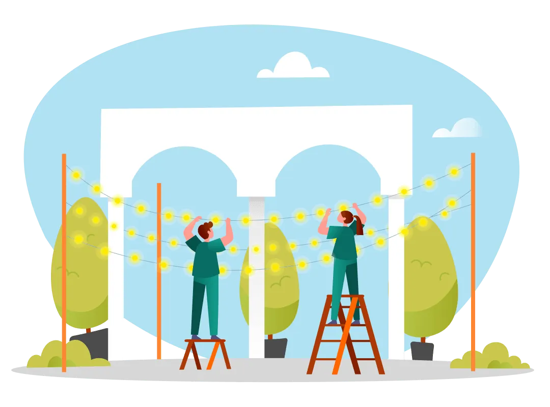 Two people stand on ladders hanging string lights outdoors near trees and a white arch structure.